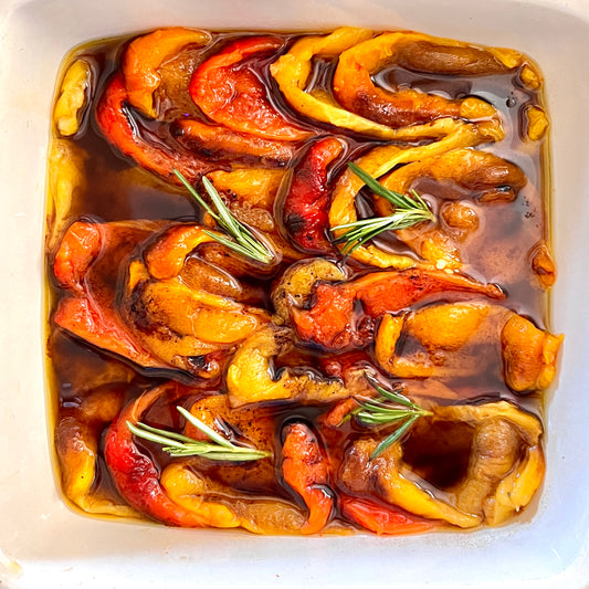 Brightly colored roasted peppers marinating in Il Bel Cuore Olive Oil